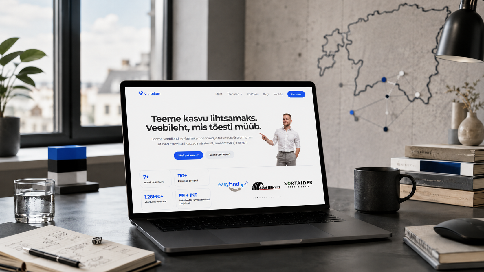 Sülearvuti Visibilioni veebilehega töölaual, taustal Eesti kaart, mis sümboliseerib väikeettevõtte kasvuteekonda ja ärisüsteemi ehitamist Eestis.